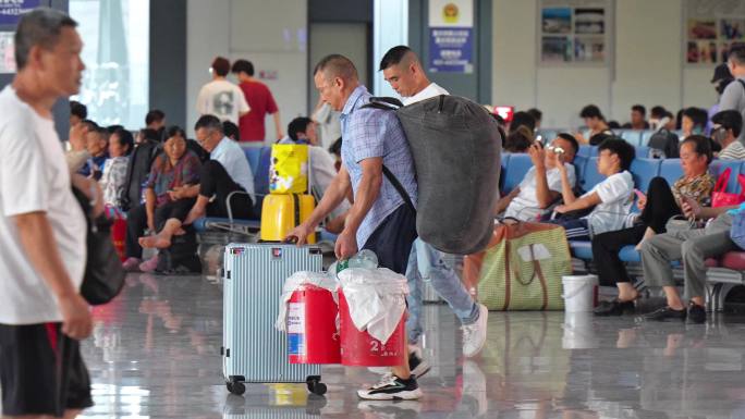 农民工大包小包在高铁候车出发外出打工赚钱