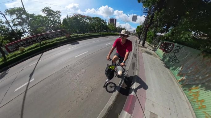 一名亚洲男子在曼谷路上骑自行车。在这个地区旅行。骑自行车锻炼