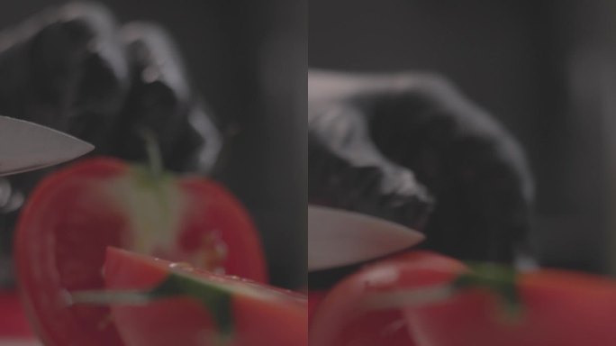 厨师在切菜板上切红番茄的特写慢动作垂直镜头