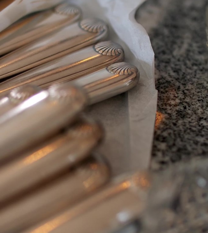 餐桌上摆放的银器和白色勺子的特写