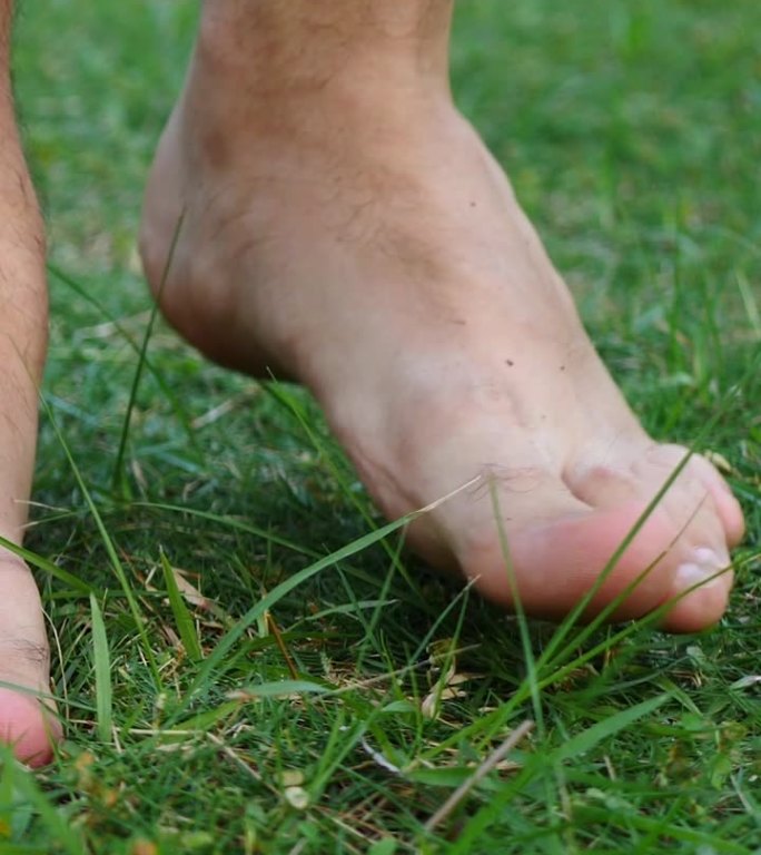 赤脚的人踩在绿色柔软的草地上