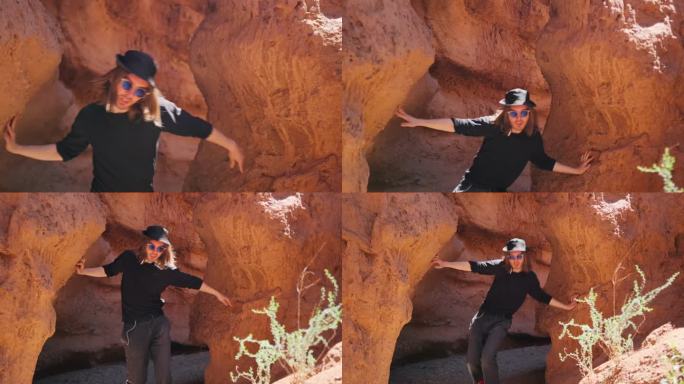 一个男人跳舞，像蛇一样扭动着，站在山间的红砂岩岩石中