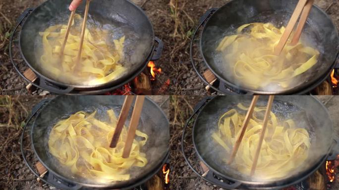 在篝火上用铸铁锅煮意大利面