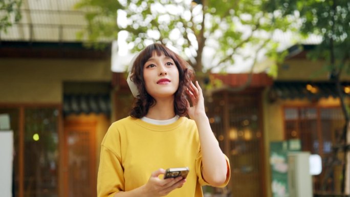 走路时戴着耳机听音乐的女人