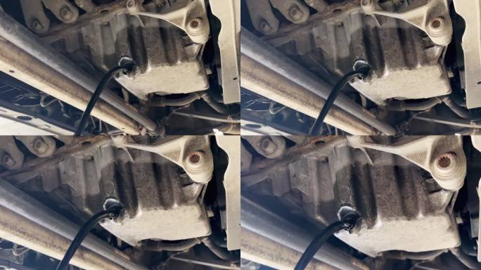 汽车发动机在漏油。机油正从发动机滴到地面上。紧急和需要立即关注汽车发动机的概念