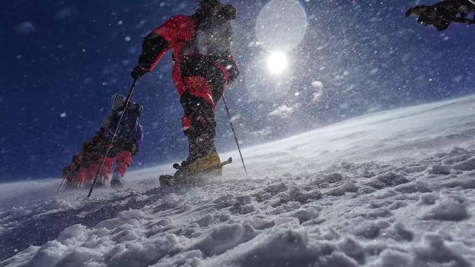 风雪中攀登慕士塔格峰雪山的登山队队员