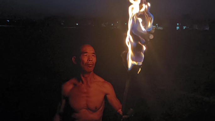 农民点燃火把火炬燃烧烈火火焰田野夜幕降临