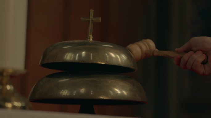 教堂内部的钟声响起。天主教教堂的钟，顶部有十字架的钟。在天主教堂内敲钟的。4k慢动作。暖色校正