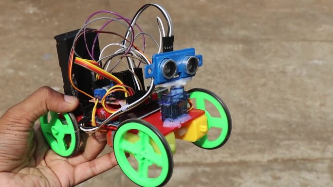 一种将超声波传感器连接到工作中的伺服器的避障机器人汽车，握在手里