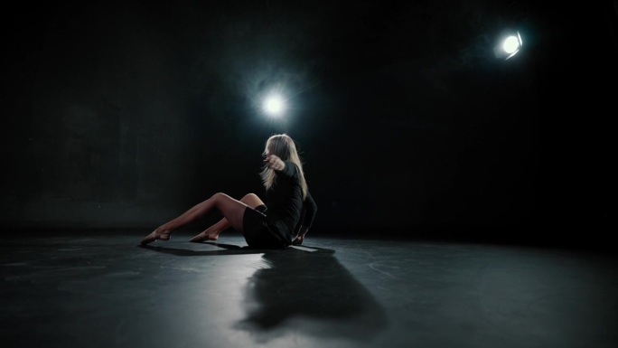 现代芭蕾舞者在黑暗中舞蹈，优雅的女士跳跃，慢动作。才华横溢的女舞者在黑暗舞蹈课上排练当代舞蹈，漂亮苗
