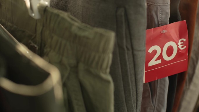 在一家服装店的货架上陈列着各种型号的牛仔裤，上面有一个红色的标签，上面写着20欧元的报价