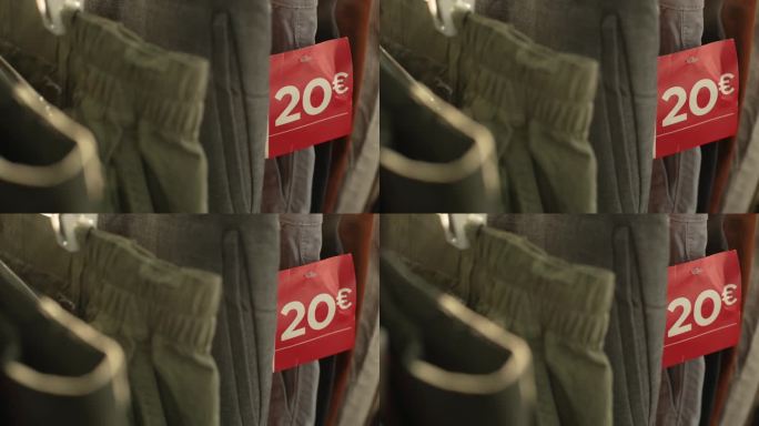 在一家服装店的货架上陈列着各种型号的牛仔裤，上面有一个红色的标签，上面写着20欧元的报价