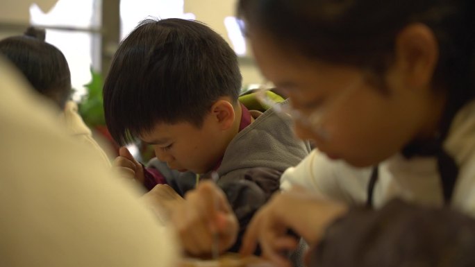 社团美术课上专注完成蛋壳画的男孩子