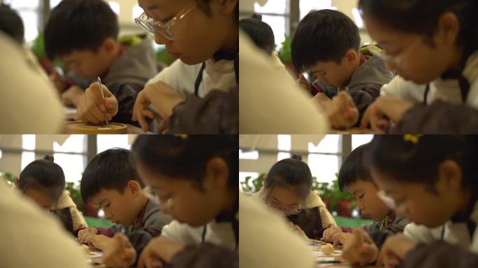 社团美术课上专注完成蛋壳画的男孩子