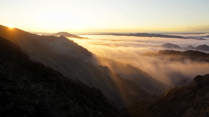 夕阳照耀下山间的云雾逐渐散开