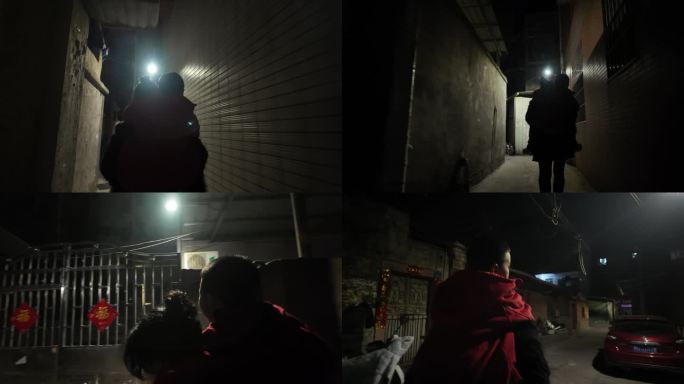 妈妈背儿子走在农村夜晚的小巷子里