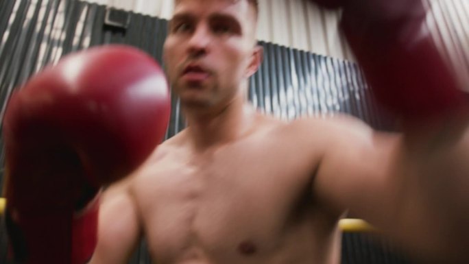 有肌肉的男人在拳击训练中对着镜头出拳