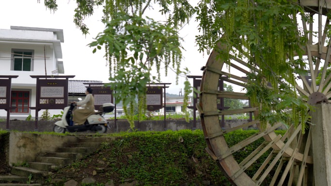 大学生村官村干部在乡村骑电动车