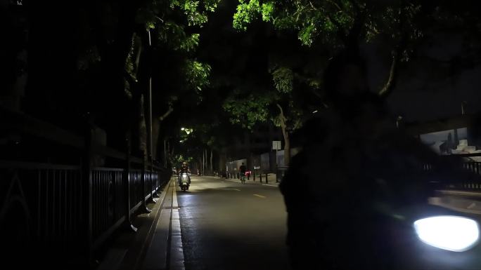 深夜马路街景夜归人，车辆驶过，电动自行车