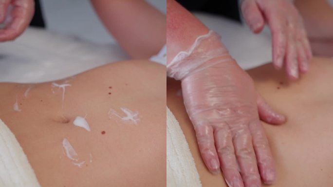 按摩腹部时涂抹面霜。身体按摩概念。