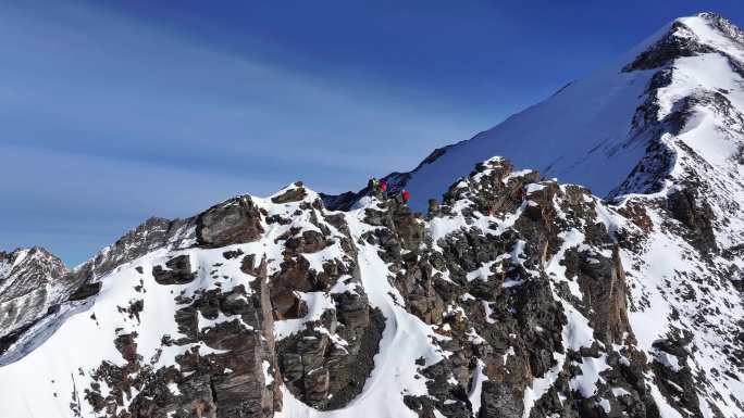 航拍攀登雪宝顶雪山的登山者翻越骆驼背