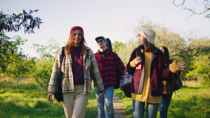一群愉快的朋友在大自然的美景中漫步，呼吸着新鲜空气，享受彼此的陪伴，四周被郁郁葱葱的绿意包围。