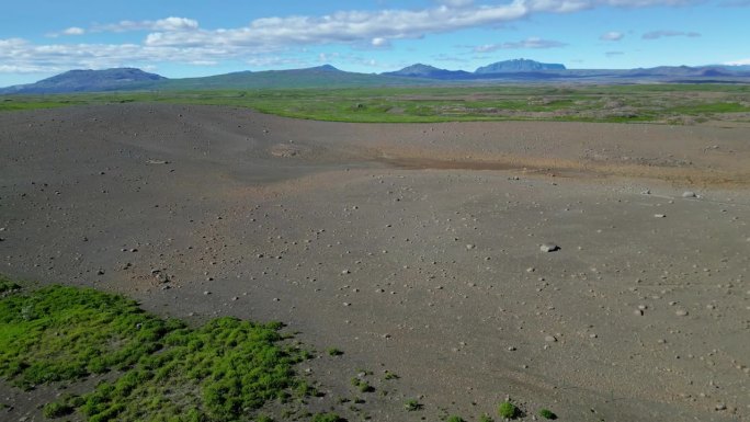 无人机航拍：冰岛广袤的绿色草地和灰色火山土壤。