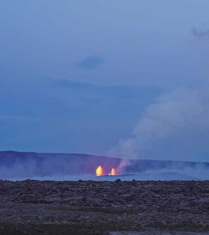 黄昏时分远处火山喷发，熔岩燃烧着周围环境。