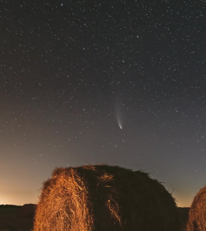 彗星Neowise C 2020 F3在夏季农业田野上方的星空中。收获后，夜空中的星星在乡村风景和干