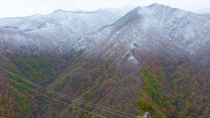 航拍初冬雪后秦岭山脉和电力铁塔输电线