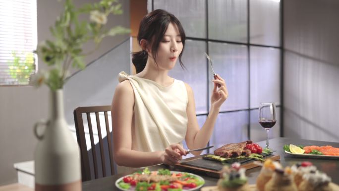 美女在餐桌上吃牛排