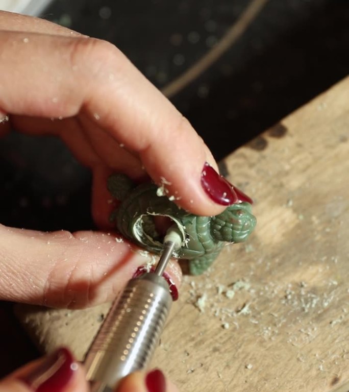 珠宝匠正在使用旋转工具对海龟戒指的底座进行打磨。