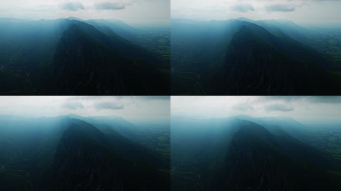 缓慢上升，触碰高空云层，揭示山峰的深度，雾雨航拍。