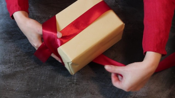 女人在礼物盒上系蝴蝶结