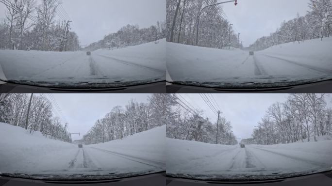 汽车在大雪纷飞中沿着雪-covered道路行驶，四周被白色树木环绕。