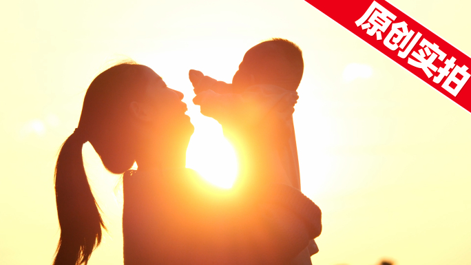 母亲抱着孩子婴儿母爱光晕父子剪影