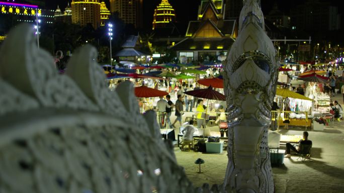 夜晚景洪寺庙雕塑和寺庙前夜市夜生活