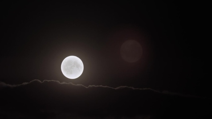 夜空中的黑色景色和淡淡的月亮在天空中移动。