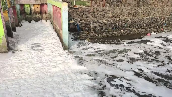 管道中流出的水带有白色泡沫的化学污染，这对人类、动物、植物和地球都不安全。对人类来说是环境灾难。