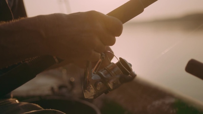 渔夫的手握着旋转钓竿。