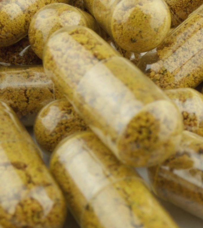 食品添加剂的生产细节：胶囊包装作为质量和关怀的象征。在姜黄的演示视频中，预防和治疗的药物以胶囊形式呈