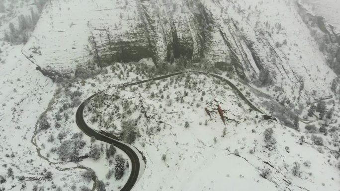 加州山区新雪覆盖的乡村道路航拍推进镜头。