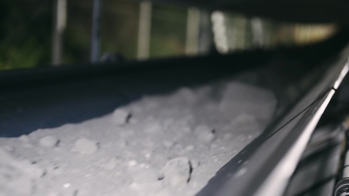 夜间运转的输送带在工业环境中运输矿石。捕捉夜间输送带运输矿石的场景，反映出繁忙的活动和在采矿及加工行