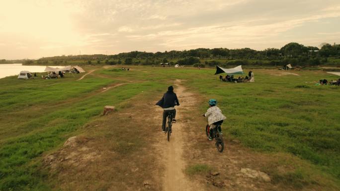 傍晚户外草坪亲子骑行