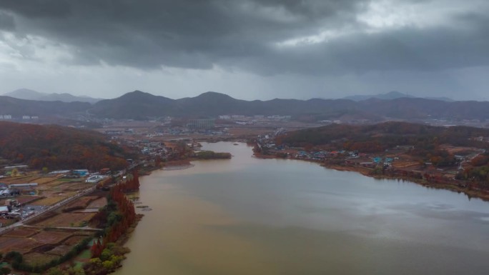 ASAN, 韩国 - 2024年10月9日：秋天的云彩聚集在宁静的阿山湖上，映照出季节变化的色彩。