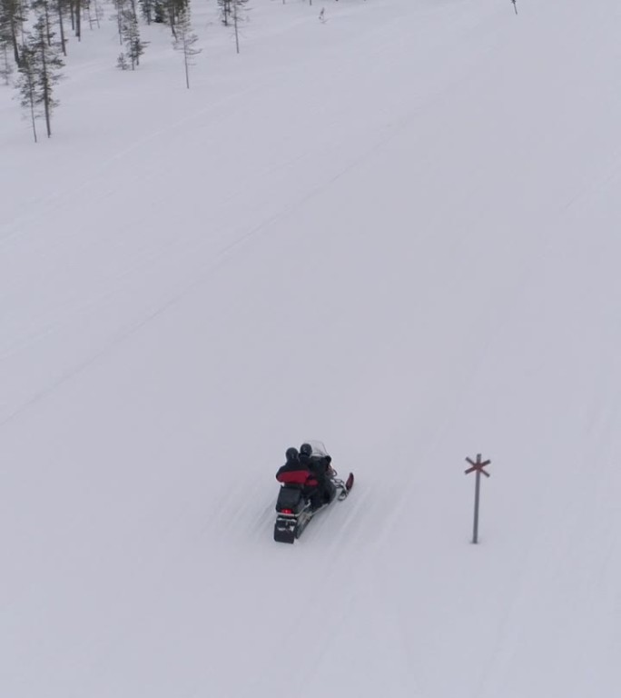 特写：男女乘坐雪地摩托穿越雪白的冬季仙境