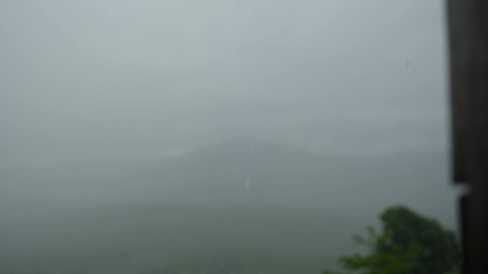 在绿树成荫的森林和山脉上空下雨