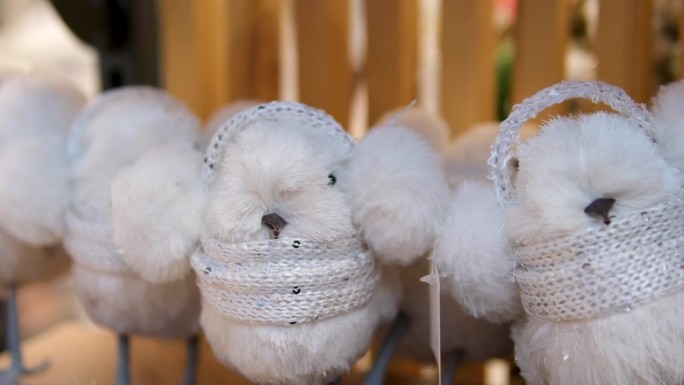 柔软的白色玩具老鼠，戴着耳机，圣诞树下的新年礼物。