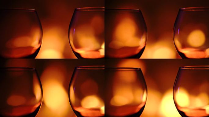 壁炉前燃烧的火焰旁，木桌上的酒杯。