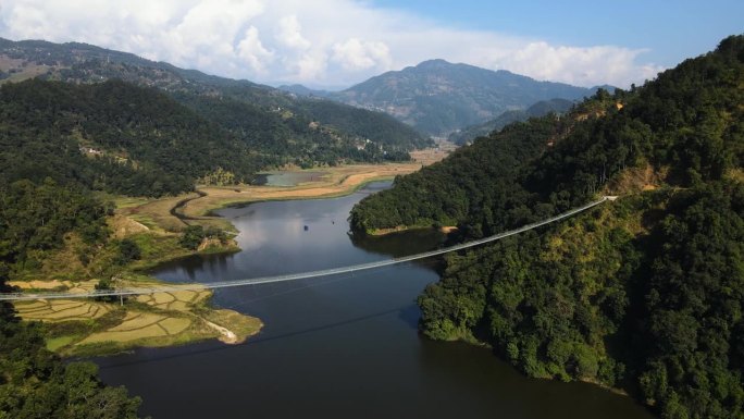 尼泊尔卡斯基地区，鲁帕湖的美丽景色，悬索桥被雄伟的马丘比丘山环绕 - 航拍镜头。